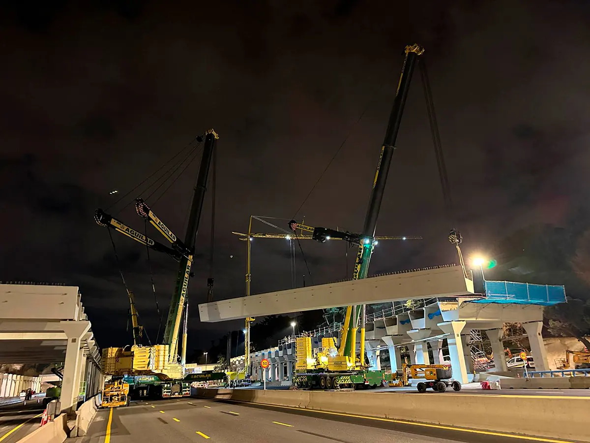 Grúas izando una viga sobre la M-30 de noche