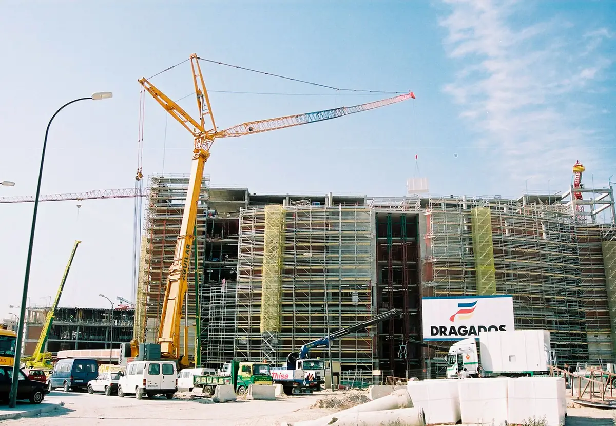 Grúa torre móvil junto a un edificio en construcción